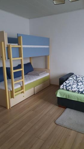 a bedroom with two bunk beds and a wooden floor at Domek na wsi 