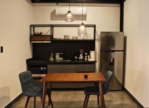 Loft titanio en excelente ubicación! في سان لويس بوتوسي: مطبخ مع طاولة خشبية وثلاجة