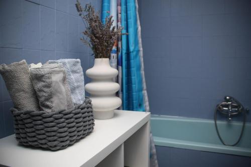 a blue bathroom with a vase and towels on a counter at Holiday house On the riverside in Ogulin