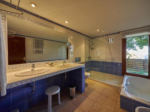 a bathroom with two sinks and a large mirror at Hotel Petit Cala Fornells in Paguera