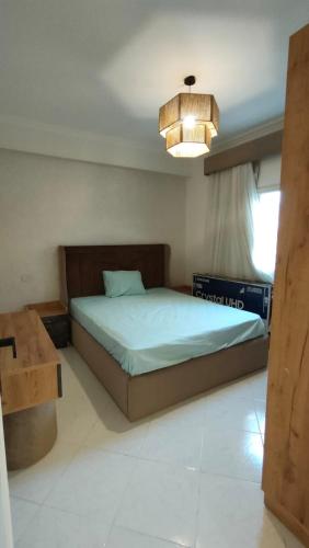 1 dormitorio con cama y lámpara de araña en مدينة نصر en El Cairo