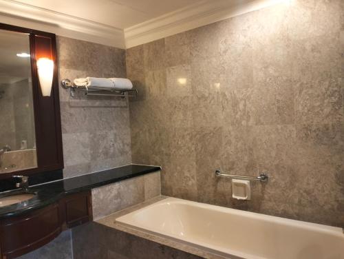 Times Square Service Suites Kuala Lumpur في كوالالمبور: حمام مع حوض ومغسلة ومرآة