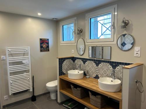 a bathroom with two sinks and a toilet at Dordogne, Le Cambou, 5 ch avec piscine et terrain 3 ha in Vergt-de-Biron