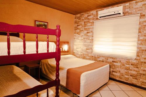 1 dormitorio con 2 literas y ventana en Pousada Costa Doce, en Río Grande