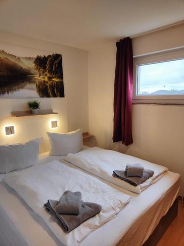 a bedroom with a large white bed with towels on it at Apartment Bergzauber - traumhafter Ausblick & Pool in Braunlage