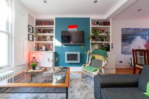 a living room with a couch and a table at Double Room with TV and Garden Hot Tub in London