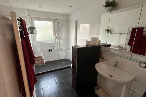 a white bathroom with a sink and a toilet at Monikas Home - Gemütliche 3-Zimmer-Wohnung im Herzen von Böblingen in Böblingen