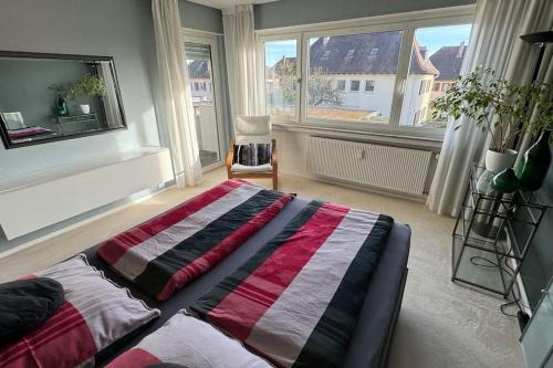 a bedroom with a large bed in a room with windows at Monikas Home - Gemütliche 3-Zimmer-Wohnung im Herzen von Böblingen in Böblingen