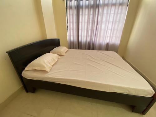 海得拉巴的住宿－HOTEL PLAZA ROOMS，卧室内的一张带白色床单和枕头的床