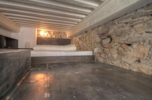 une chambre avec un lit et un mur en pierre dans l'établissement Lyon centre, quartier Hôtel de ville, à Lyon