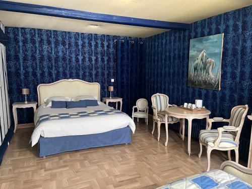 a bedroom with a bed and a table and chairs at Les Wyllos in Thiéblemont-Farémont