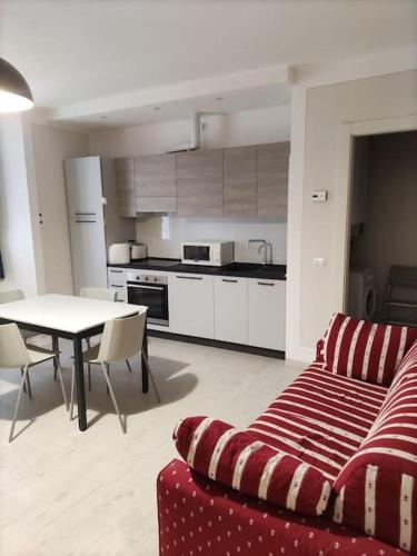 ein Wohnzimmer mit einem roten Sofa und einer Küche in der Unterkunft Appartamento Le Rondini A in Intra