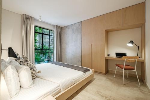 1 dormitorio con 1 cama y escritorio con ordenador portátil en Nido Condesa by RentinBA en Ciudad de México