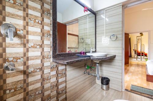 uma casa de banho com um lavatório e um espelho em Johnnie Holiday Homes em Arpora