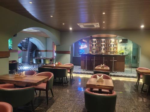 un ristorante con tavoli e sedie e un bar di The Sarai, Hotel a Jaipur