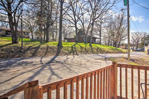 a wooden fence next to a road with trees at Lakefront Gem with Screened Porch and Game Room! in Shell Knob