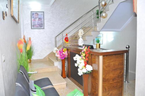 a room with a staircase with a table and flowers at APPART HOTEL OUED EDDAHAB in Khenifra