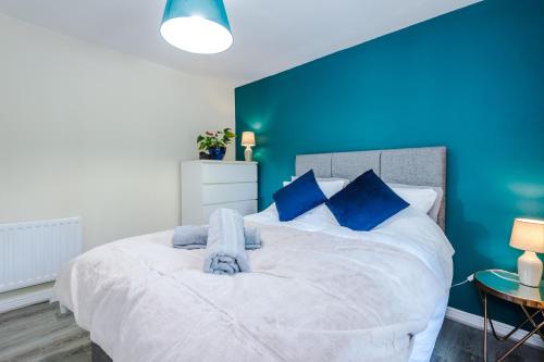 a bedroom with a large bed with a blue wall at Contractors & Families, Free Parking, Fast WiFi, RHS Bridgewater in Worsley