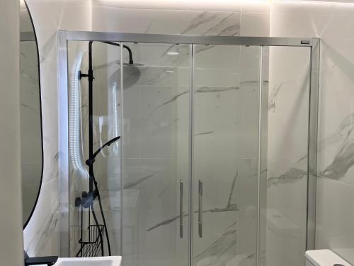 a shower with a glass door in a bathroom at H. Pelayo Autocheck-In Suites con Jacuzzi in Noja