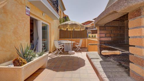 a patio with a table and chairs on a building at Palm Beach House in Corralejo