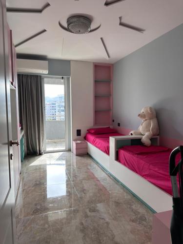 um quarto com duas camas com um urso de peluche sentado em cima em View Apartment em Kashari