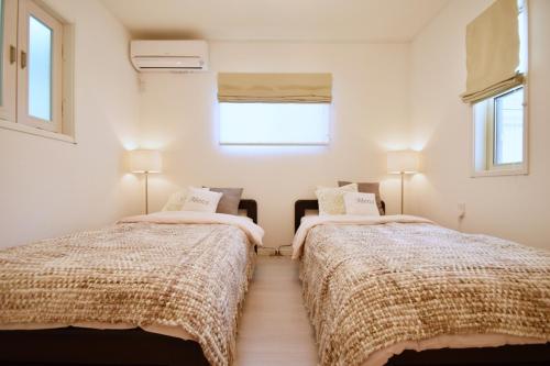 2 camas en una habitación con 2 ventanas en Magical Dream House ★ Maihama - Vacation STAY 12402 en Tokio