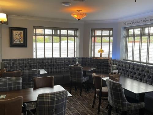 a dining room with tables and chairs and windows at The Ivy Tree in Stockton-on-Tees