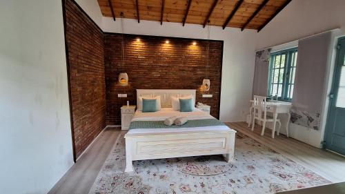 a bedroom with a bed and a brick wall at Kandalama Lodge in Dambulla