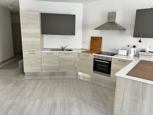 a kitchen with a sink and a stove top oven at Amazing 2 bed apartment Gozo in Għajnsielem