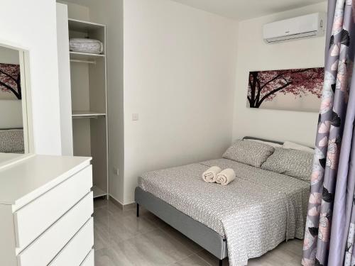 a bedroom with a bed with two towels on it at Amazing 2 bed apartment Gozo in Għajnsielem