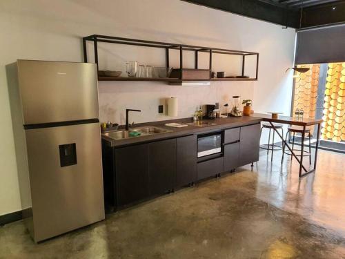 a kitchen with a stainless steel refrigerator and a table at Loft platino en excelente ubicación! in San Luis Potosí