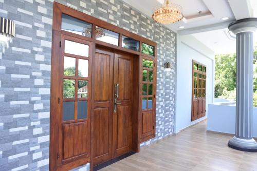 korytarz z drewnianymi drzwiami i ceglaną ścianą w obiekcie Hajiz Palace w mieście Dżafna
