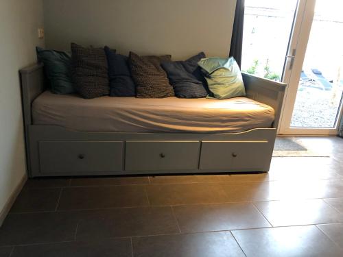 een bed met kussens in een kamer bij B&B Typisch Lelies in Liessel