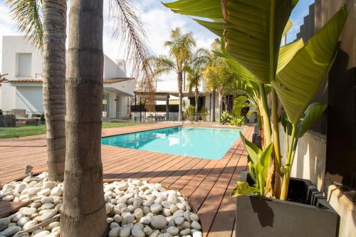 a swimming pool with a palm tree next to a house at Las vegas in Benicàssim