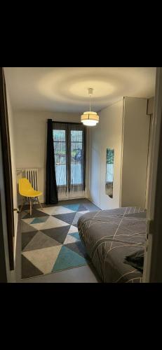 ein Schlafzimmer mit einem Bett und einem gelben Stuhl in der Unterkunft Chez Nico in Nizza