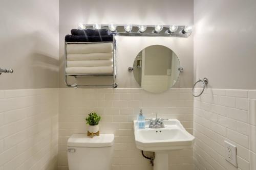 a bathroom with a sink and a toilet and a mirror at Spacious Downtown New Orleans Vacation Rental in New Orleans