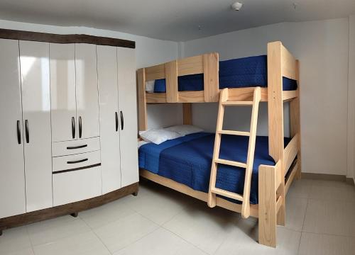 1 Schlafzimmer mit 2 Etagenbetten und einer Leiter in der Unterkunft Airbnb Paracas Inn in Pisco