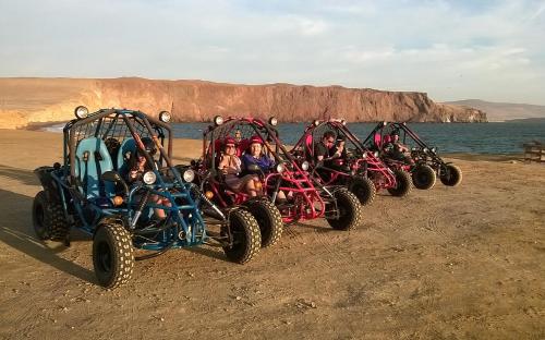 a group of people riding atvs on the beach at Airbnb Paracas Inn in Pisco