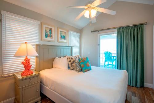 a bedroom with a bed with a ceiling fan and a window at Hawks Cay Resort in Marathon
