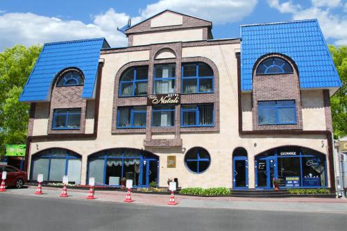 a building with a blue roof on a street at Hotel Villa Natali in Chişinău