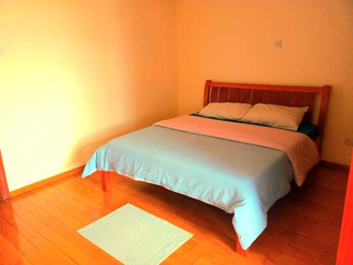 a small bedroom with a bed with orange walls at Lavington Room1 in Nairobi