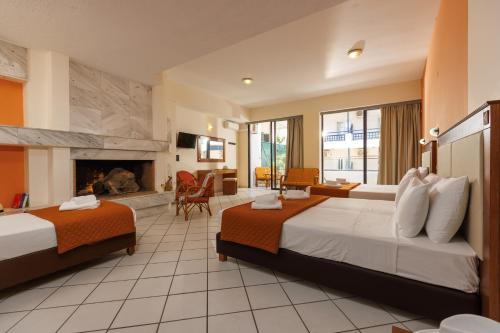ヘルソニソスにあるAgrabella Hotelのベッド2台と暖炉付きのホテルルームです。