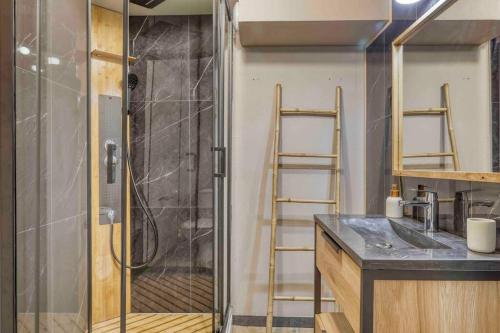 La salle de bains est pourvue d'une douche avec un lavabo et une porte de douche en verre. dans l'établissement Appartement «Chez Paulette»situé à 25Km chamonix , à Saint-Gervais-les-Bains