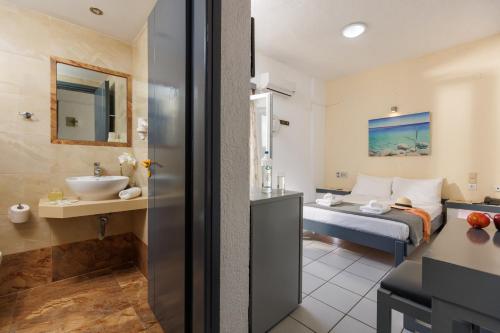 um quarto de hotel com uma cama e um lavatório em Agrabella Hotel em Hersonissos