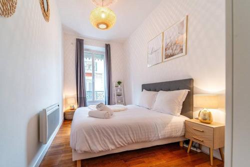 - une chambre avec un lit blanc et une fenêtre dans l'établissement Coeur centre ville Grenoble - charme de l'ancien, à Grenoble