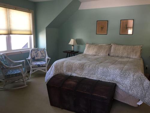 a bedroom with a large bed and a chair at Waterfront Home on Bantam Lake with Private Beach in Morris