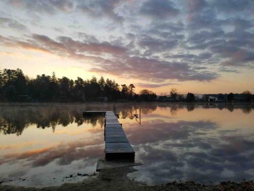 a dock in the middle of a lake at sunset at Waterfront Home on Bantam Lake with Private Beach in Morris