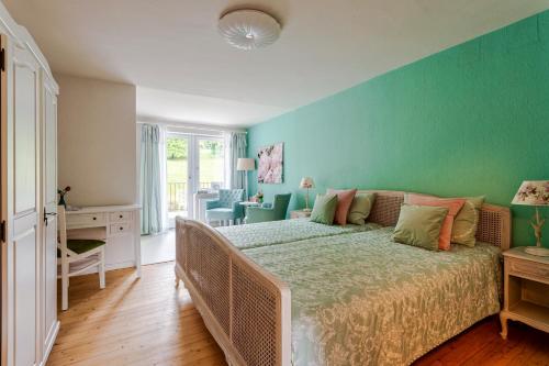 sypialnia z łóżkiem i zieloną ścianą w obiekcie Pension Landhaus w mieście Brombachtal
