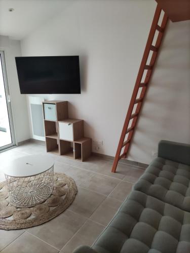un salon avec un canapé et une télévision dans l'établissement Maison avec jacuzzi proche plages, à Avrillé