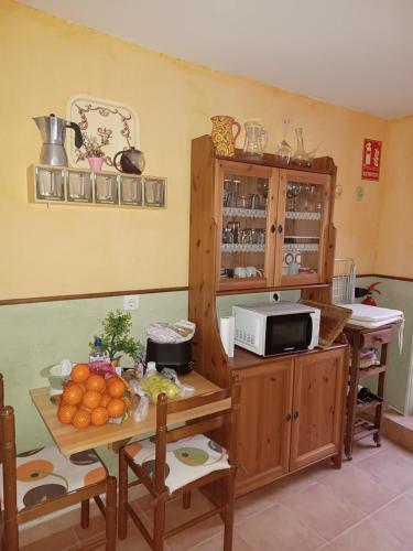 una cocina con una mesa con fruta. en Casa rural san juan, en San Juan del Monte